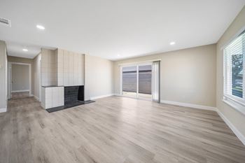 a living room with a fireplace and a sliding glass door at Wescove Apartments